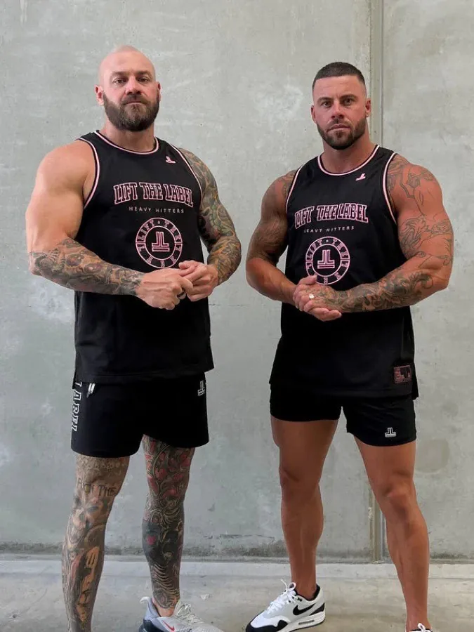 Two men wearing black and hot pink Lift The Label College Logo jersey tanks and shorts